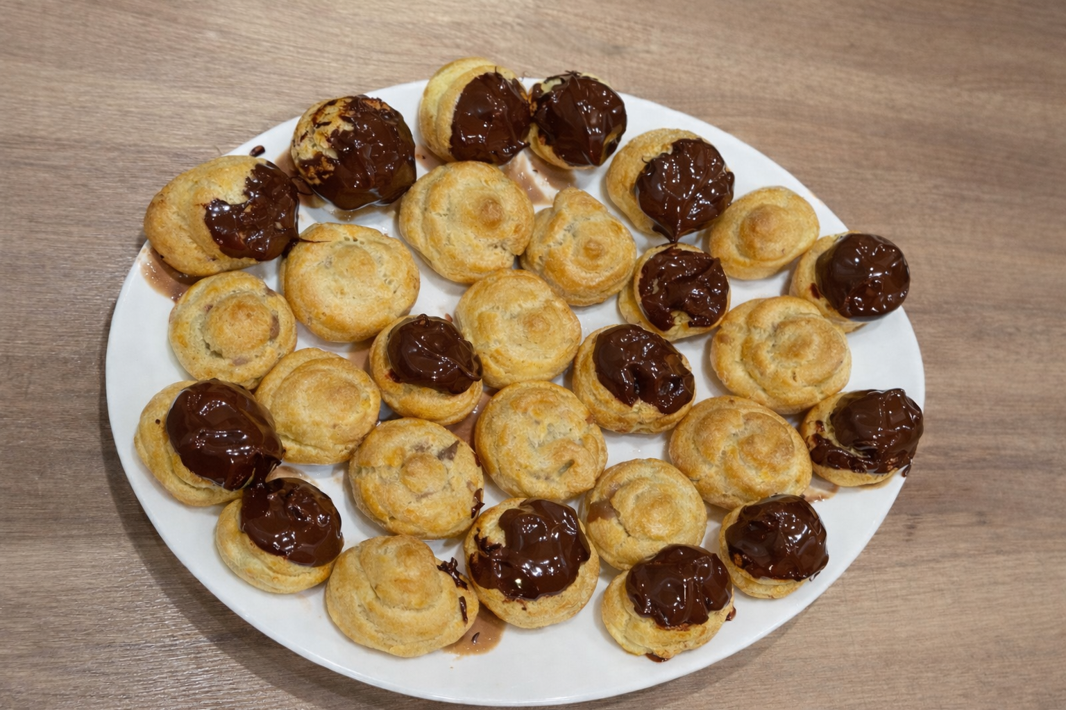Piatto di bignè fatti in casa, preparati con pasta choux e farciti con crema pasticcera. Soffici, leggeri e perfetti come dessert o per un vassoio di dolci della tradizione.