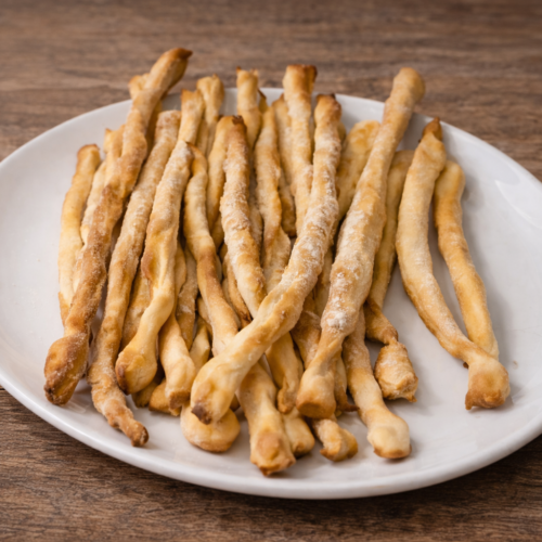 Grissini fatti in casa croccanti su piatto bianco