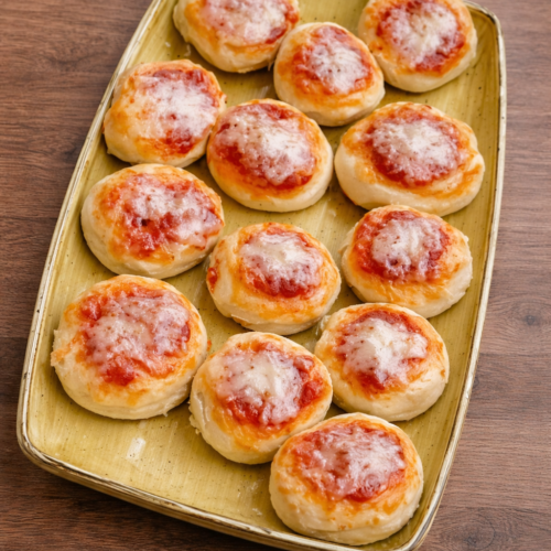 Pizzette allo yogurt senza glutine con pomodoro e mozzarella, servite su vassoio su tavolo in legno