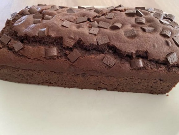 Plumcake al cacao con pepite di cioccolato su piatto bianco