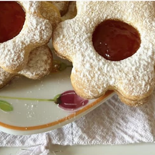 Biscotti occhi di bue senza glutine a forma di fiore con marmellata di fragole e zucchero a velo