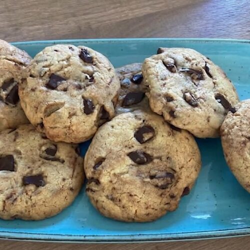 Cookies alla Nutella con cioccolato fondente dorati e morbidi su piatto azzurro