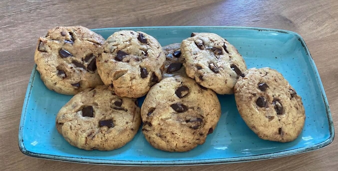 Cookies alla Nutella con cioccolato fondente dorati e morbidi su piatto azzurro