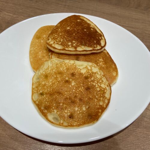 Pancake soffici allo yogurt dorati serviti su piatto bianco