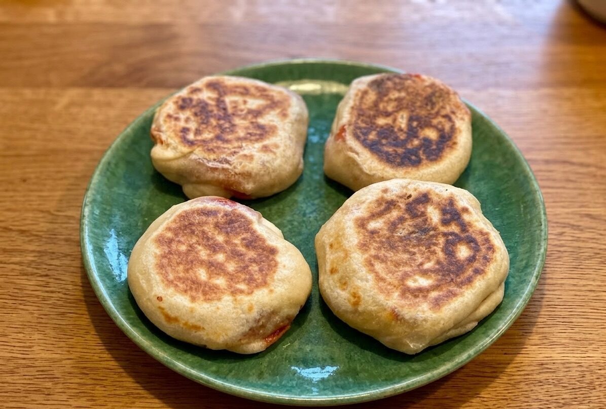 Pita ripiena in padella dorata con provola filante su piatto verde