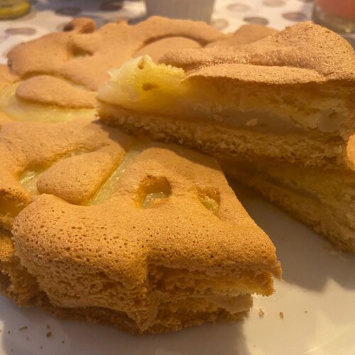 Torta al limone con crema soffice tagliata su piatto bianco