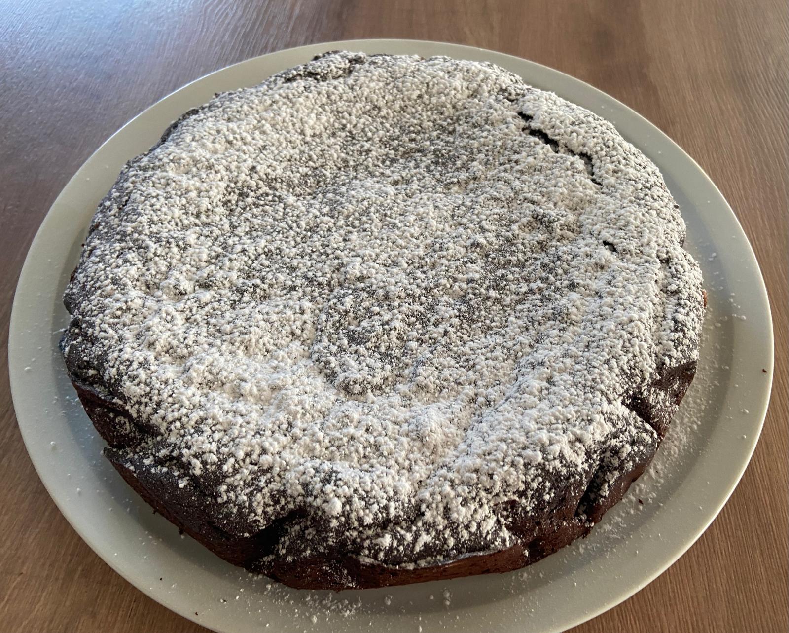 Torta al cioccolato e ricotta senza glutine con zucchero a velo su piatto bianco
