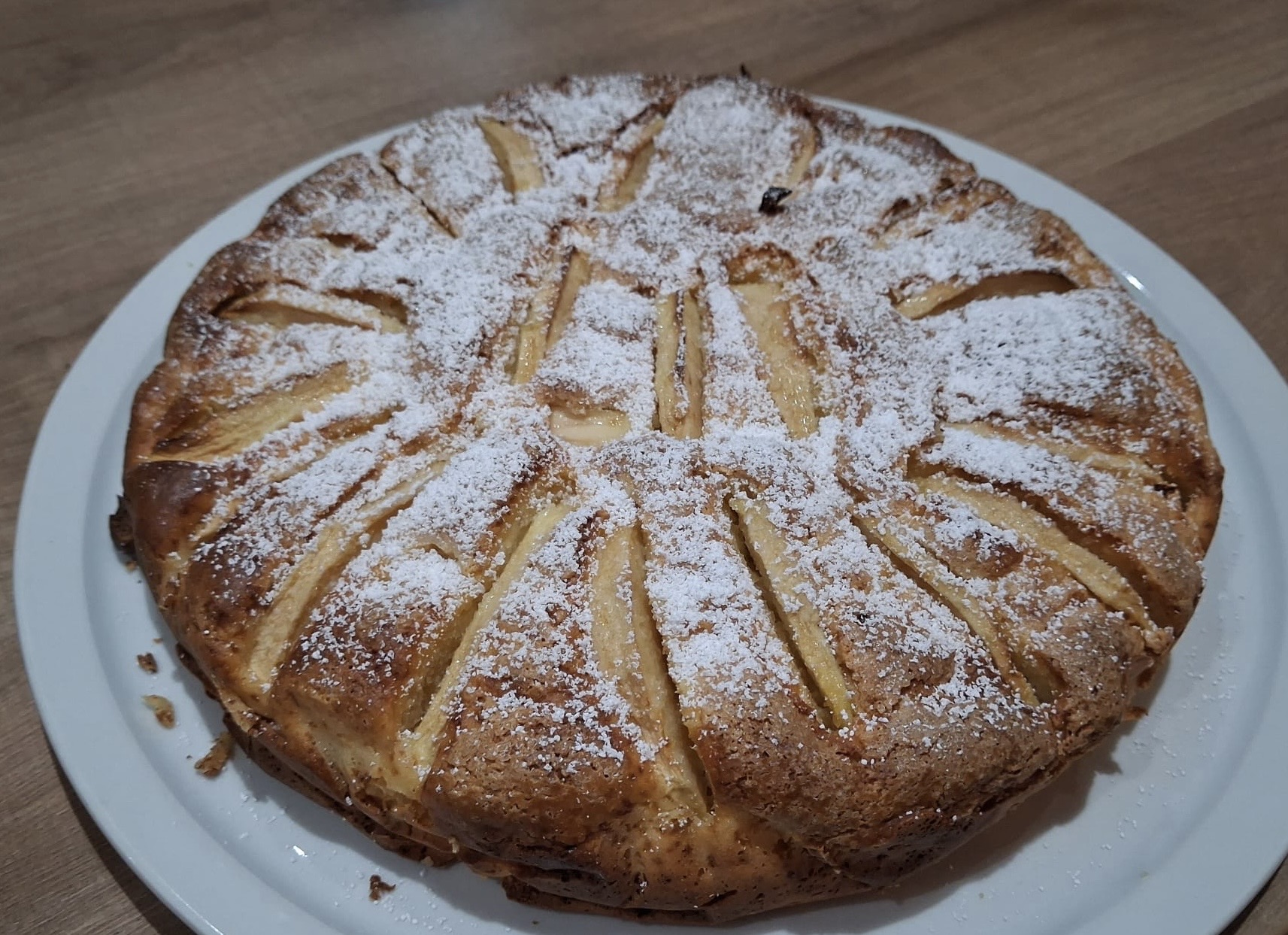 Torta di mele e ricotta con zucchero a velo su piatto bianco